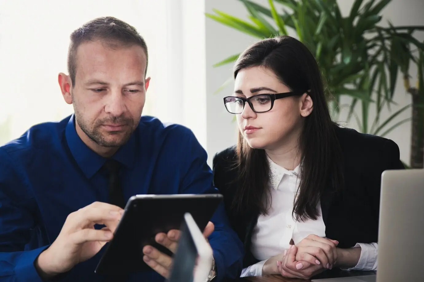Mann mit Tablet, ein Kollege in der Nähe.